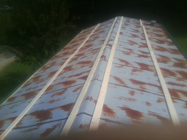 Rusted metal roof panels with new wood purlins before replacement — Storm Damage Roof Repair in Conklin by Roofing Brothers
