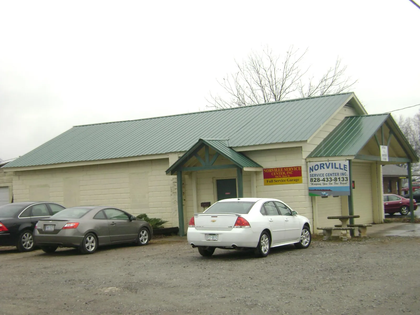 Green metal roof on a service garage with a covered entry in Conklin