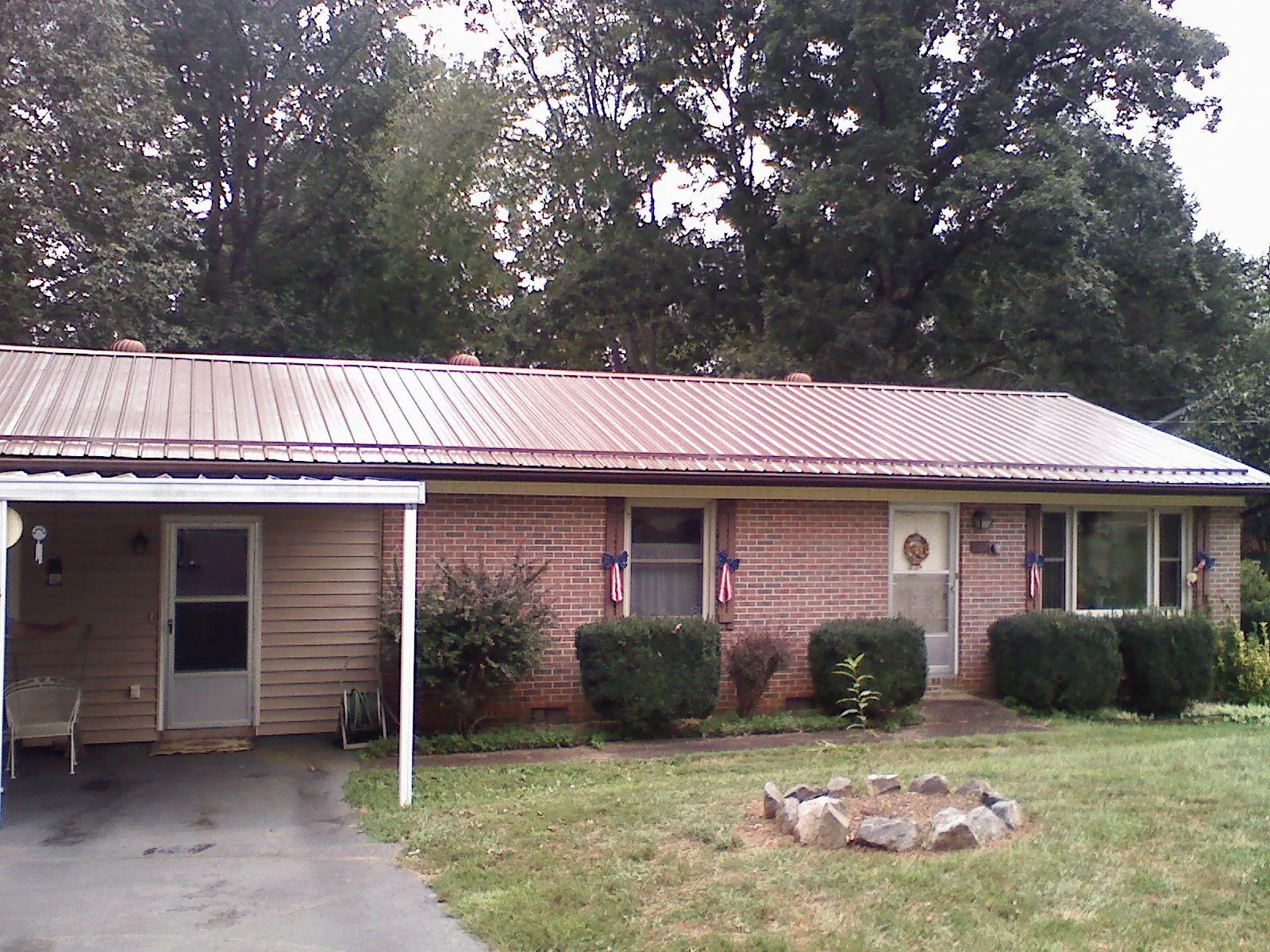Bronze metal roof and carport on a brick ranch home — Roof Repair work by our crew in Conklin